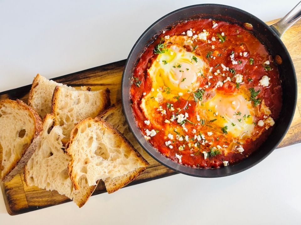 Shakshuka — eggs poached in spiced tomato sauce with feta and cilantro